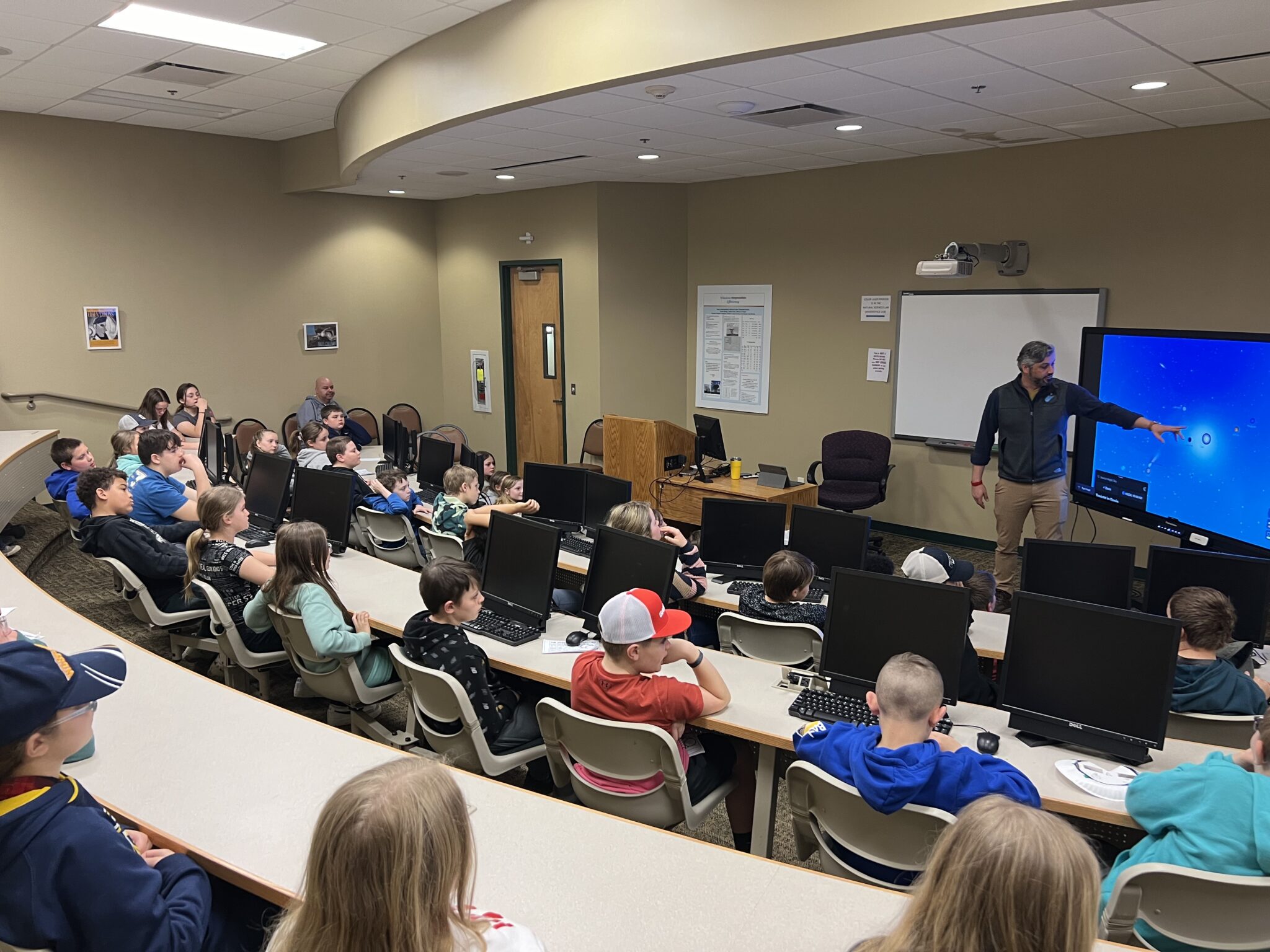 Executive Director Ryan Haupt demonstrates the dynamics of an eclipse event to a group of students.